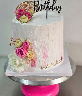 Textured cake with pink roses and gold birthday topper