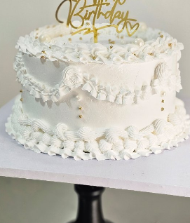 White piped vintage cake with gold Happy Birthday topper