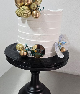 White ridged cake with gold balloon spheres