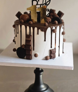 Chocolate drip cake with chocolate bars and candy